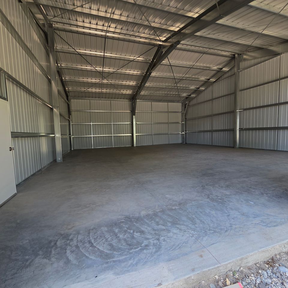 Empty steel building interior with insulated wall panels and smooth concrete floor