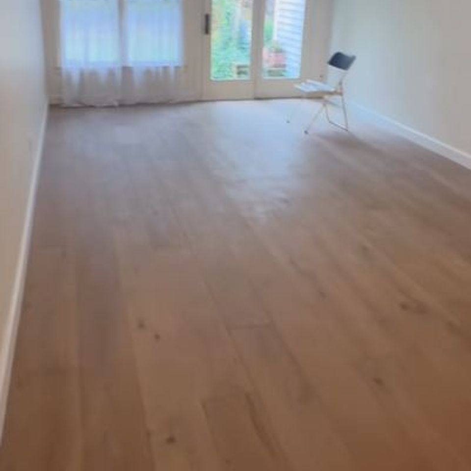 Newly installed wood flooring in empty living room by general contractor in Suffolk County NY