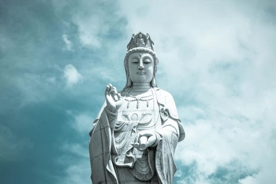 Kwan yin statue against blue sky with wispy clouds