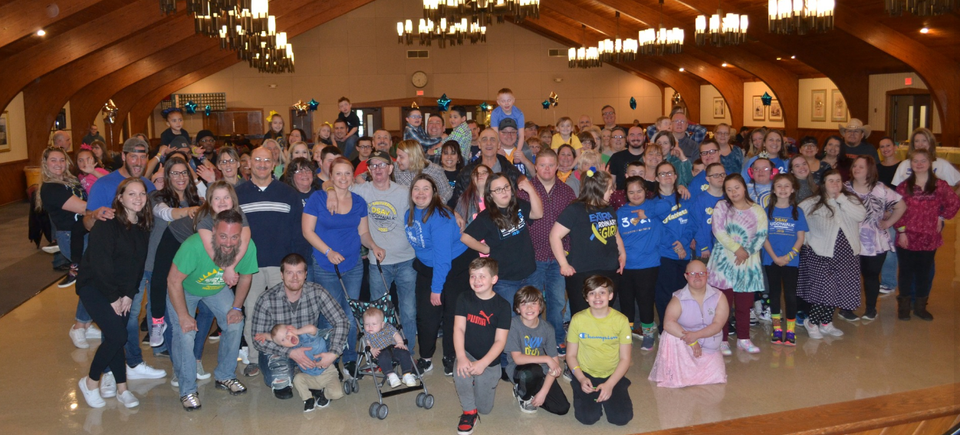 Large group of DSAV members, families, and volunteers gathered for a community event inside a banquet hall.