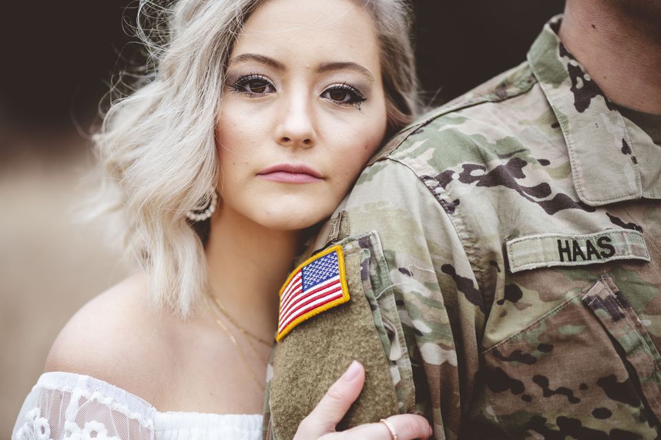 Shallow focus attractive female holding american soldier s arm