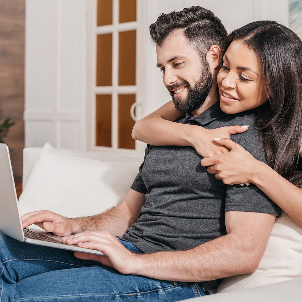 Man working on laptop with woman looking over his shoulder