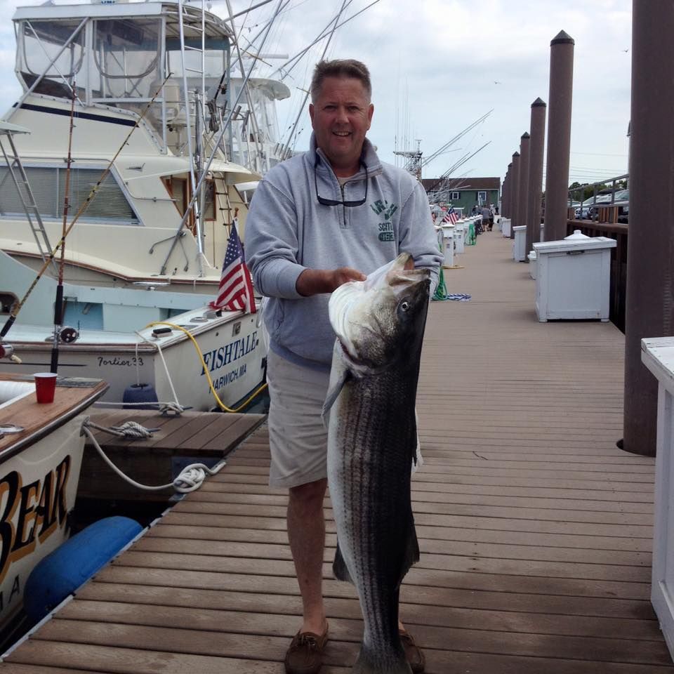 Man on dock holding huge striper