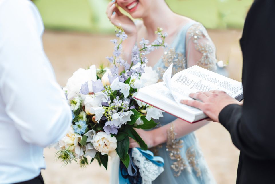 Bride smiling while holding flowers during wedding moment