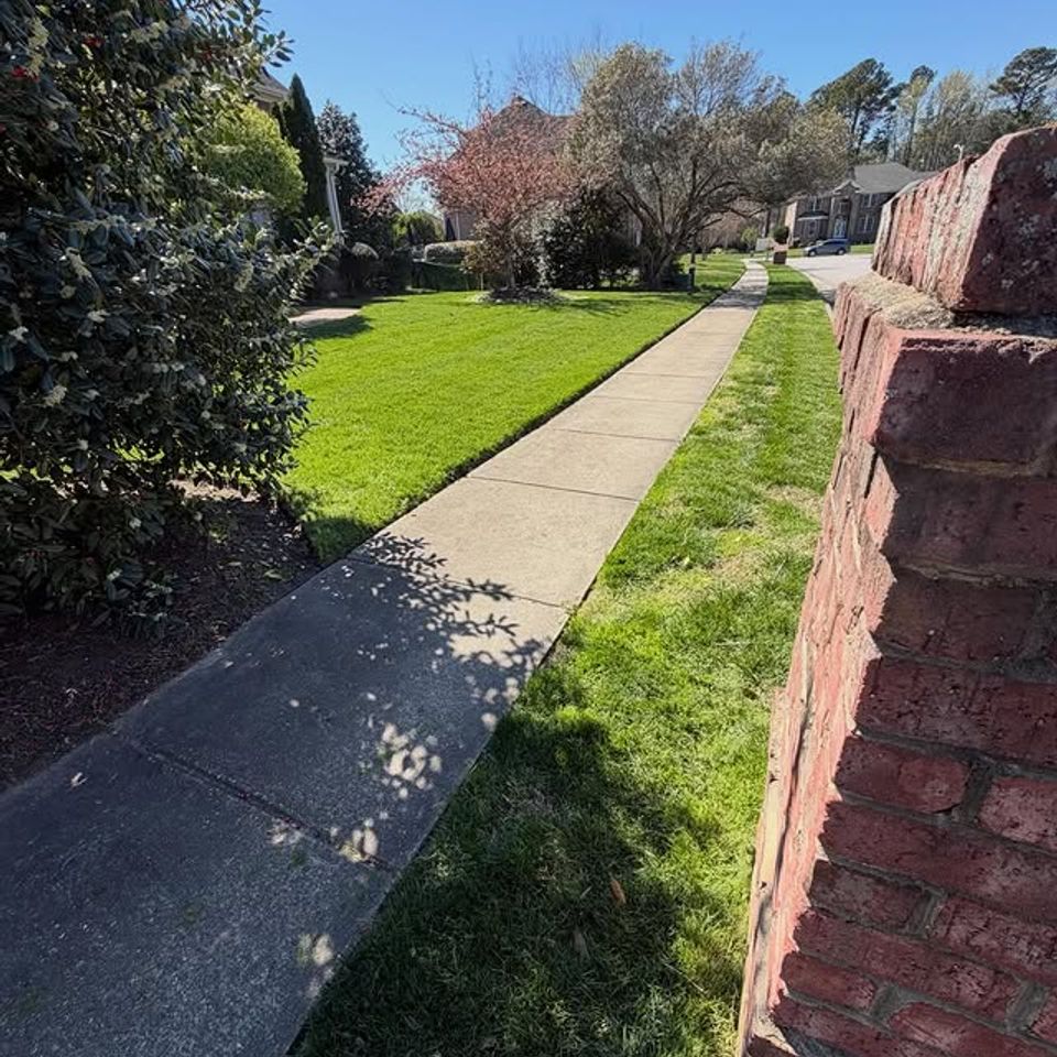 Sidewalk, with newly cut grass on the sides, done by Get A Mow On Lawn Care LLC of Chesapeake VA