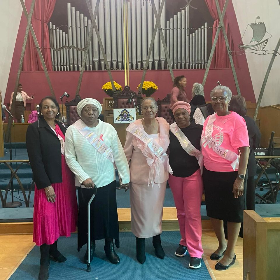Church members posing together inside Grace Evangelistic Temple Church in front of the sanctuary and pipe organ during a special fellowship event.