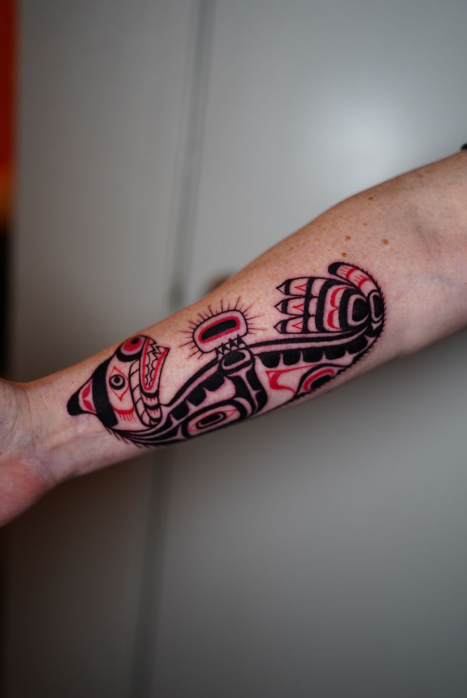 Image of a Mayan or Aztec dog lying down in red and black colored ink