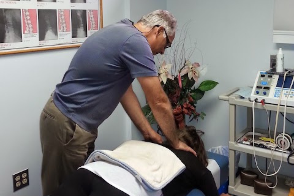 Dr. Dean Massaro, D.C. performing a chiropractic spinal adjustment on a patient during an in-office treatment session at Massaro Chiropractic LLC.