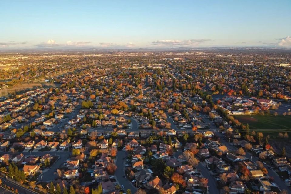 Aerial drone view of Rocklin, California, showcasing luxury residential neighborhoods, historic granite outcroppings, and the protected native oak tree canopy of Placer County.