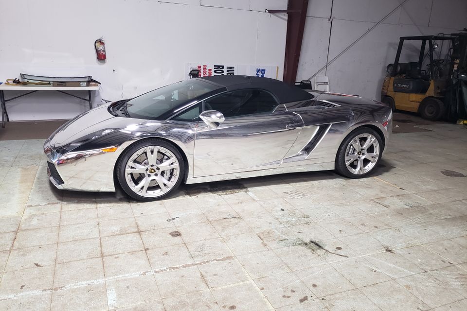 Luxury convertible inside an auto glass shop for specialty custom glass installation and replacement.
