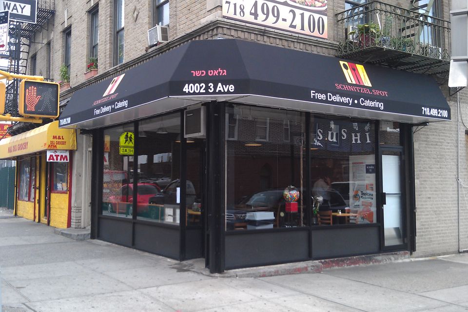 Black corner awning wrapping two sides of the storefront.