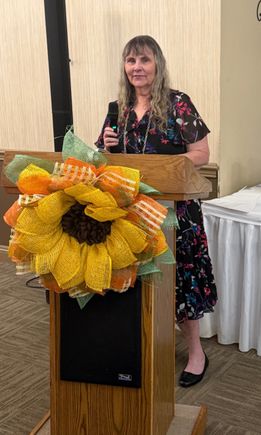Speaker holding a microphone at a podium during the Mahoning Valley September meeting.