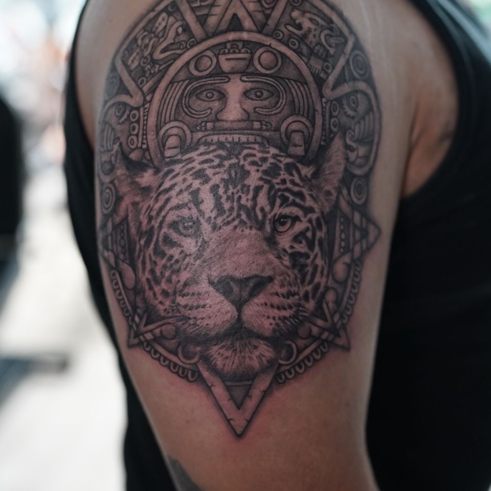 Image of a tattoo representing a jaguar and mayan symbols surrounding the very detailed jaguar