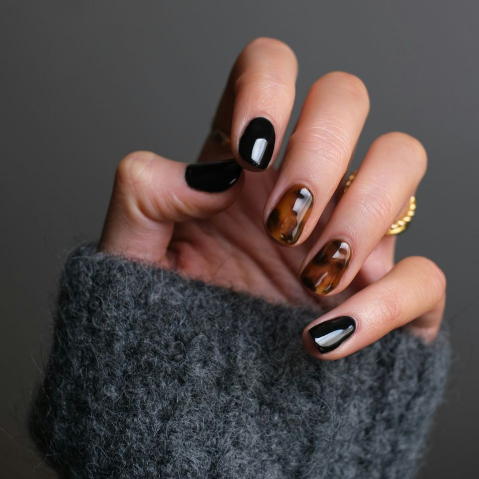 A woman with brown and black painted hand nails