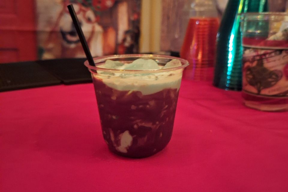 Cocktail in a cup with ice on a red table at a holiday party