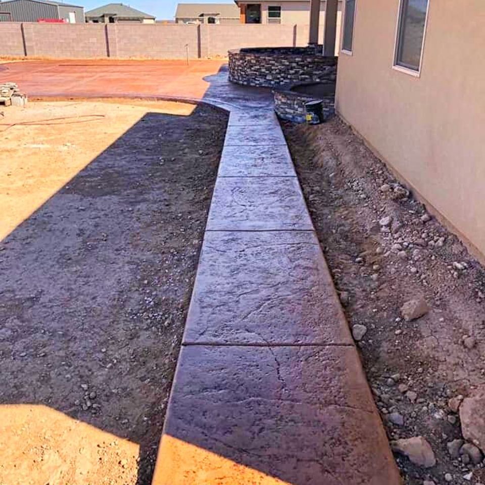Decorative sand-textured cement pathway connecting to a matching backyard patio for a cohesive residential landscape by Roseville Concrete Solutions.