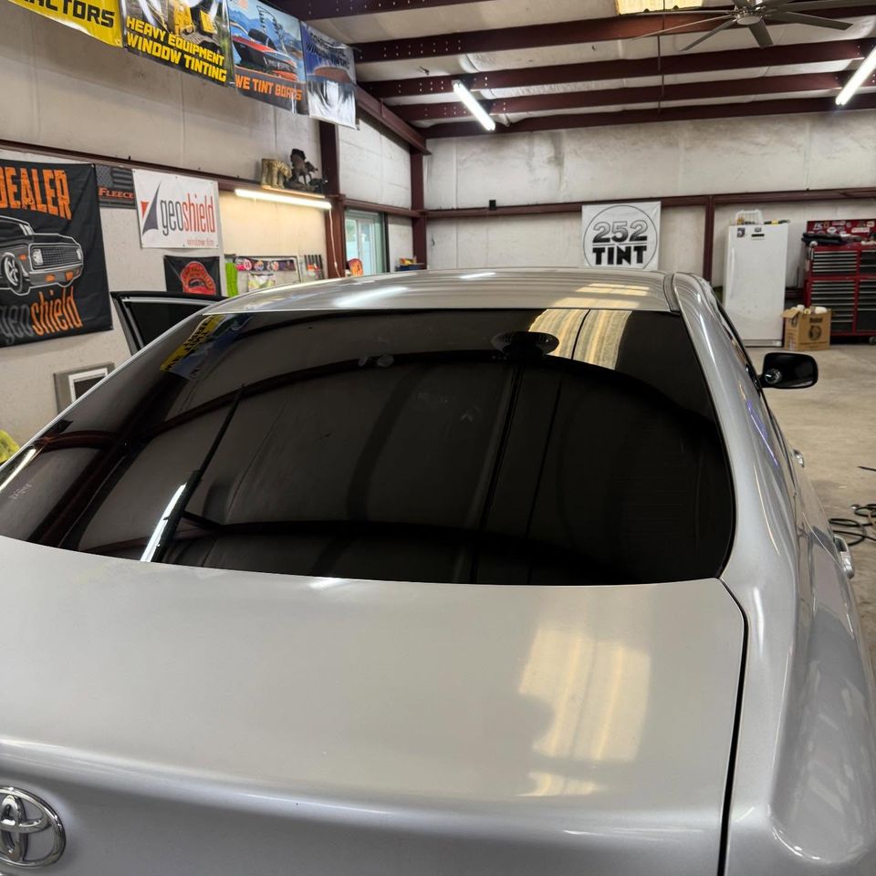 Silver Toyota Camry with freshly tinted rear windshield inside a Moyock NC tint shop