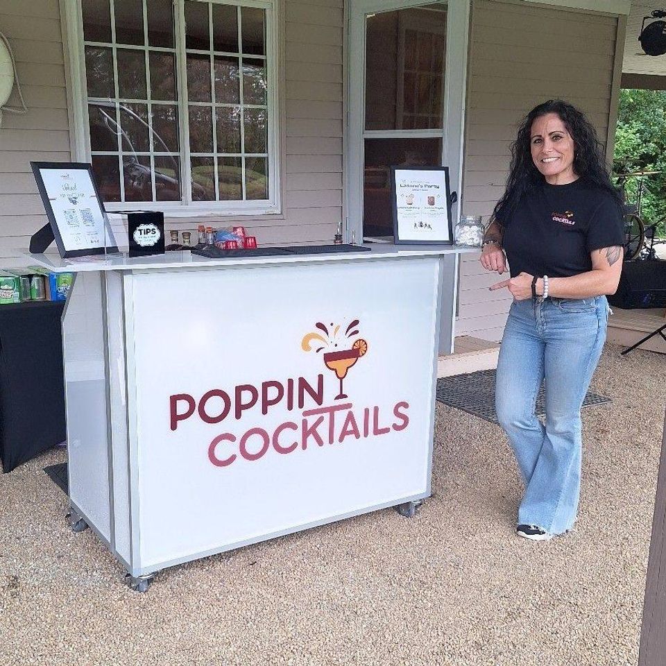 Poppin Cocktails owner next to the full mobile bar setup at a private party