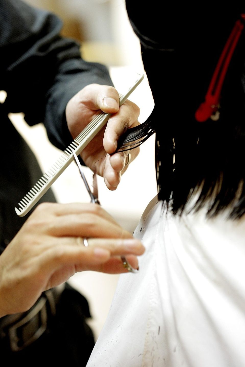 Barbering student performing hait cut at beauty school