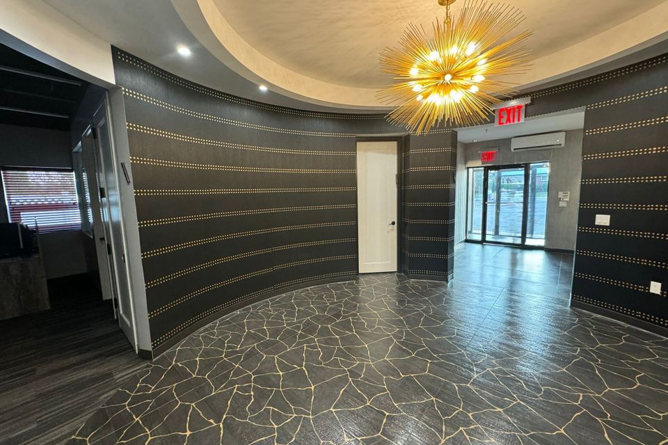 Elegant office lobby with a chandelier and curved wall detailing.