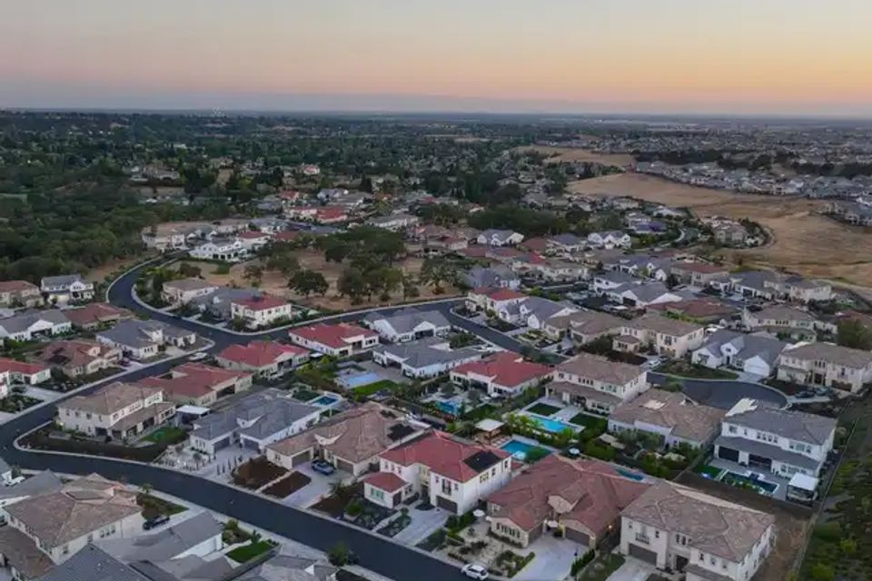 Aerial drone photography of Loomis, California, featuring large residential estates, open pastures, and the signature dense oak tree canopy of Placer County