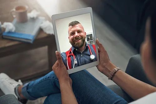 Smiling patient in a telehealth visit using a tablet  symbolizing virtual access to safer sex counseling at be well berlin.