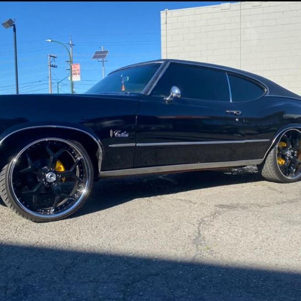 Classic black muscle car with tinted windows in a gallery photo