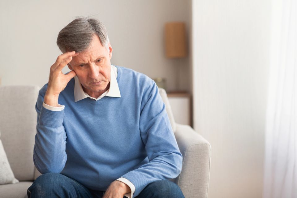 Sad Elderly Man Thinking About Loneliness Sitting On Couch At Home
