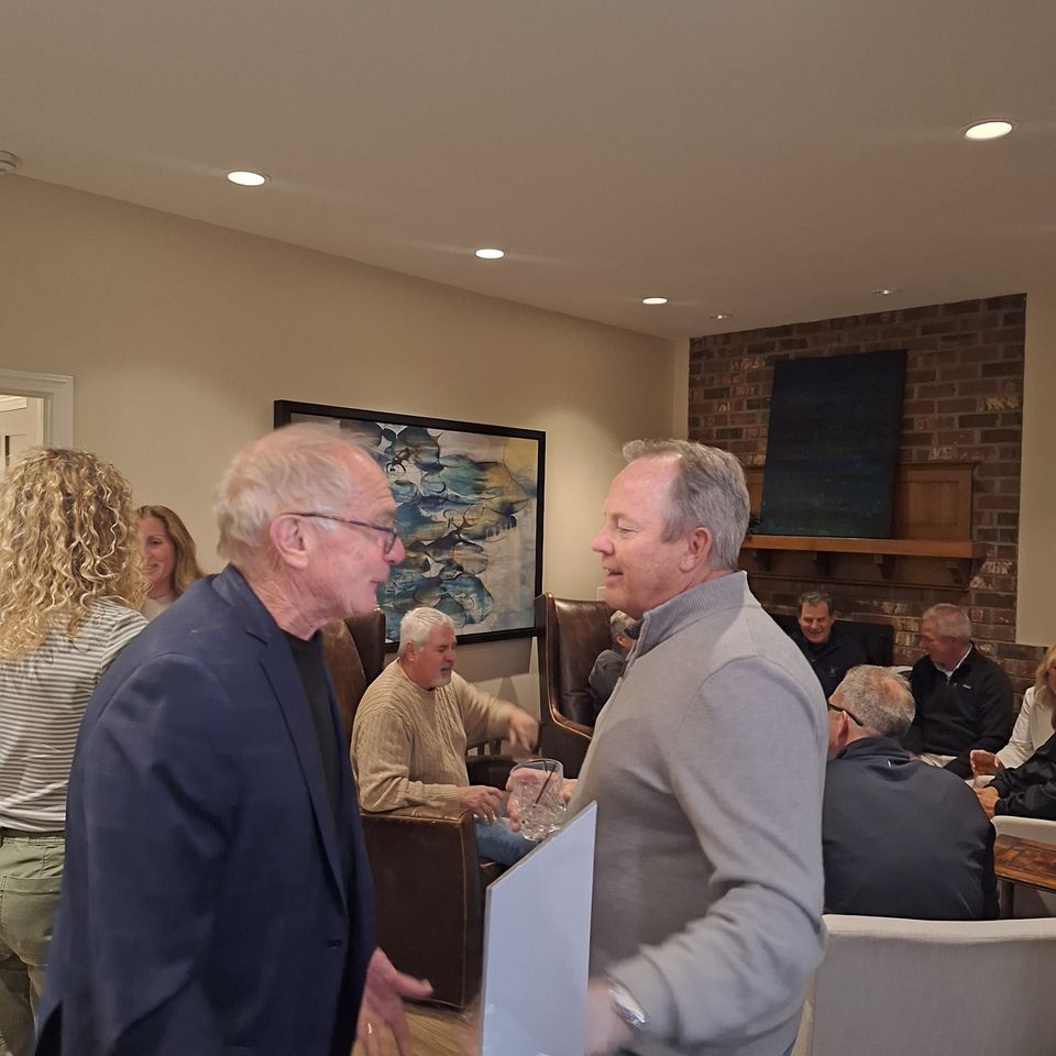 Guests socializing indoors with drinks at a social gathering