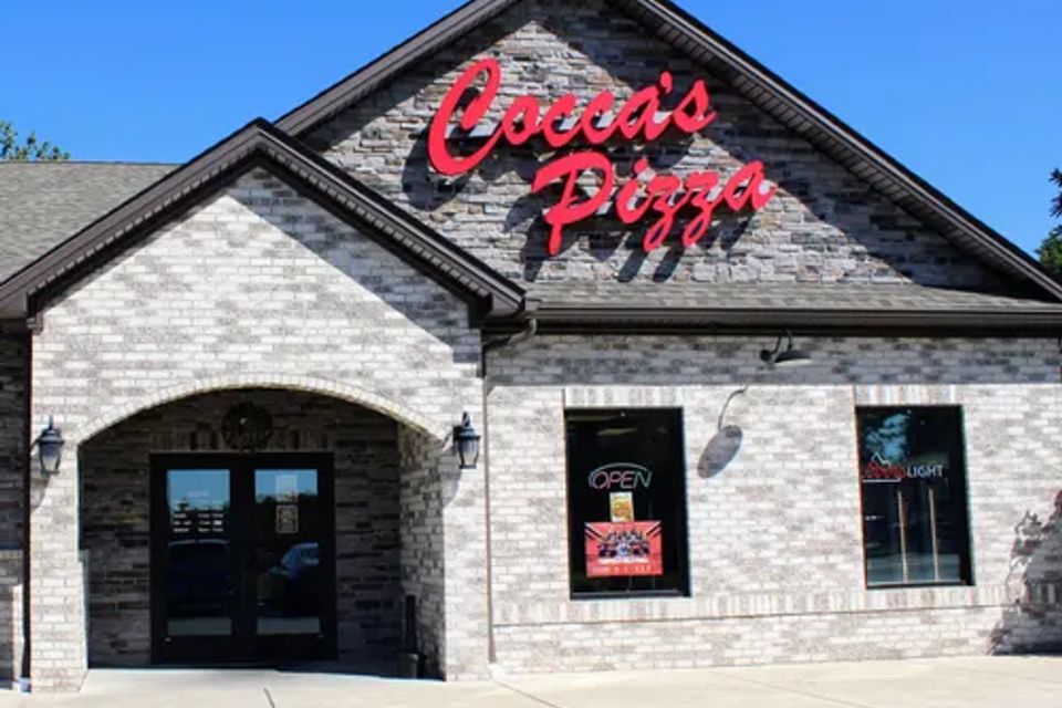 Cocca’s Pizza Canfield, Ohio location with a stone exterior, arched entrance, and prominent red storefront sign.