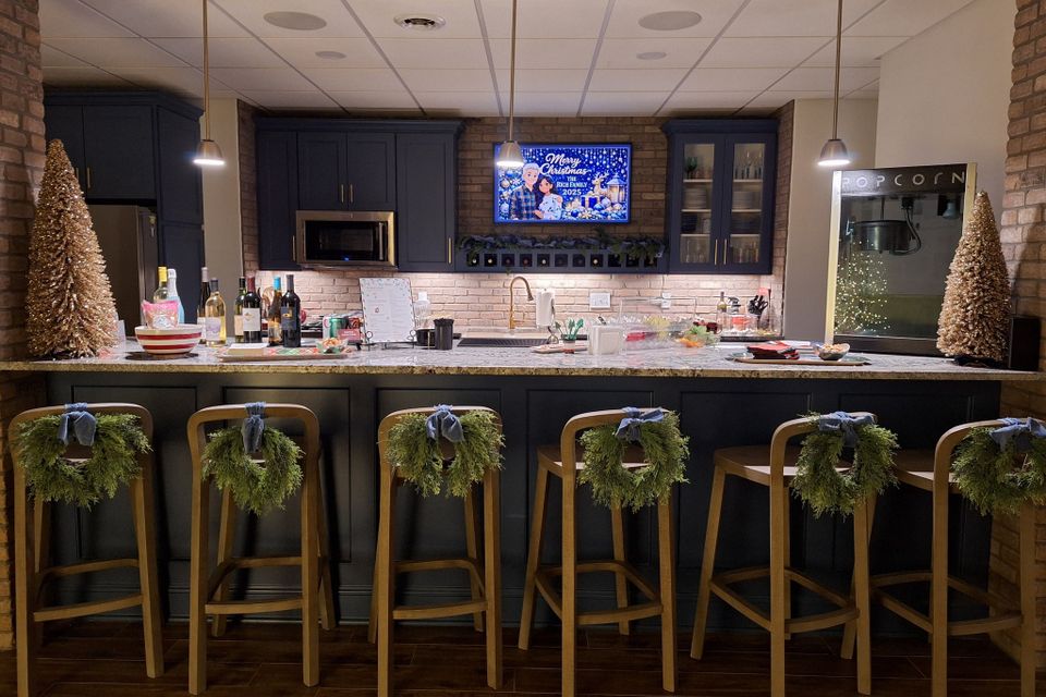 Decorated bar with stools, wreaths, and drink setup for a holiday party