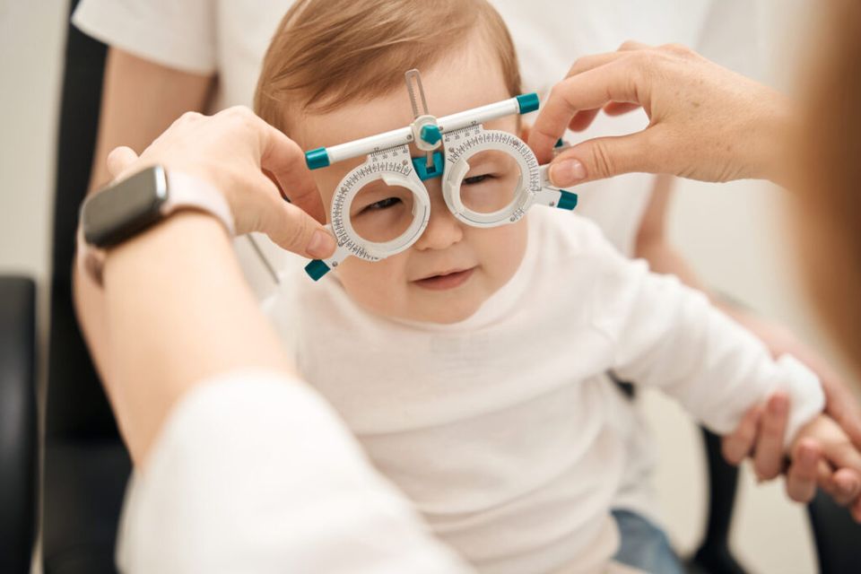 Eye doctor fitting a older infant boy for corrective lenses 1024x683