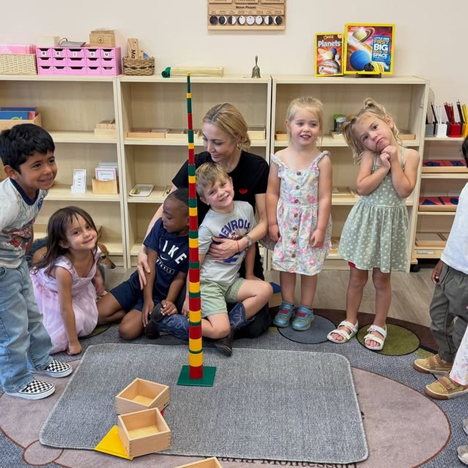 Teacher and preschool class gathered around a completed bead tower in a Montessori classroom in Palmdale CA