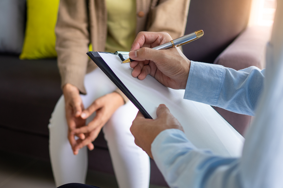 Chiropractor conducting a patient consultation and taking notes during an initial evaluation at Massaro Chiropractic LLC.