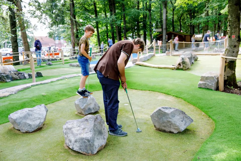 Vistacreate 485224542 stock photo school kid boy playing mini golf with father happy child and dad young man having (1)