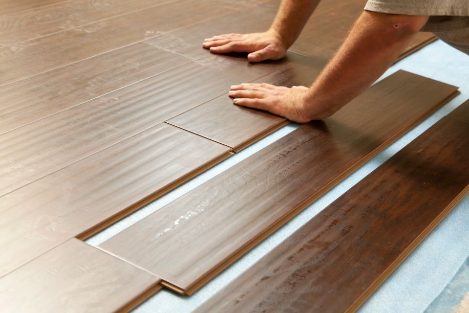Man Installing New Laminate Wood Flooring 