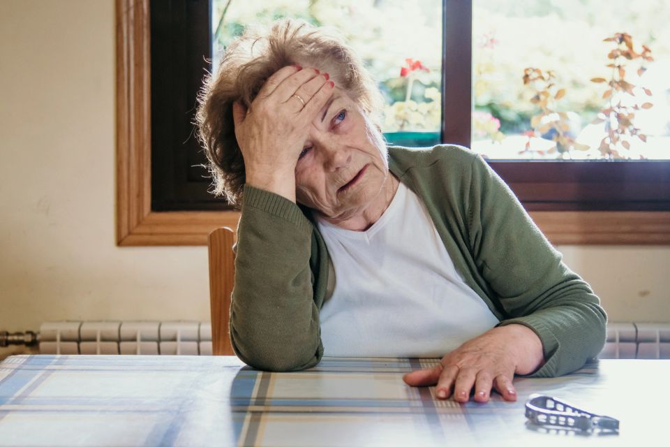 Portrait of an older woman with a headache expression