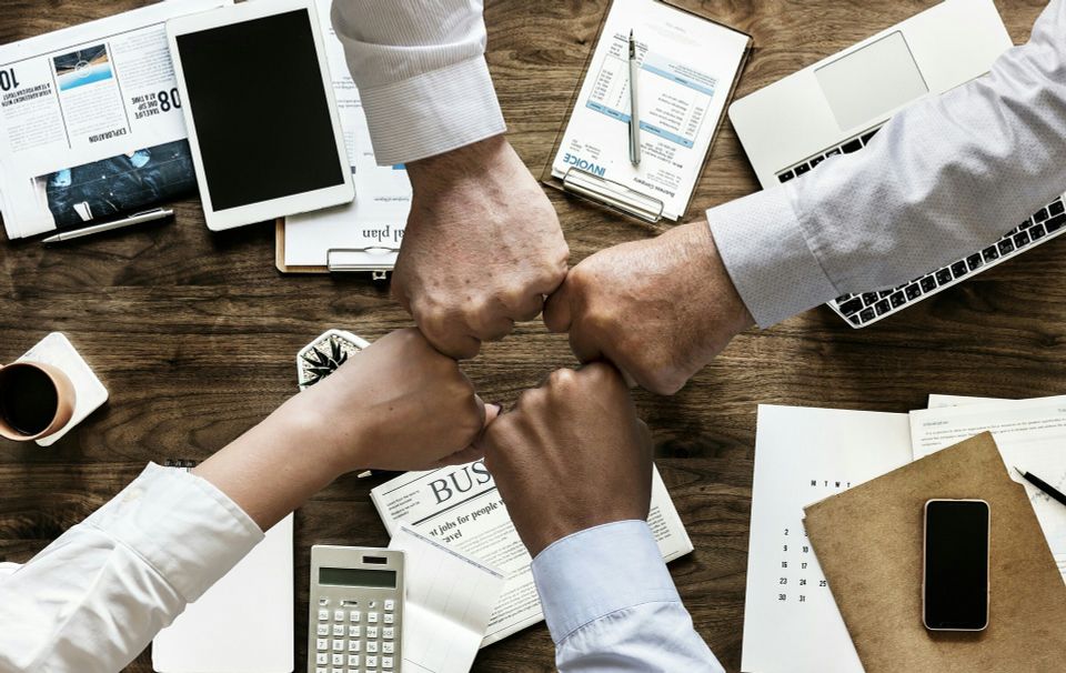 Office team fist bumping a success