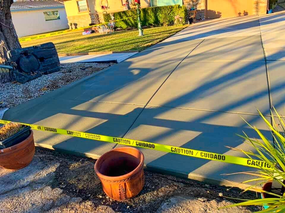 Newly poured cement patio curing behind safety caution tape during a professional residential installation project by Roseville Concrete Solutions.