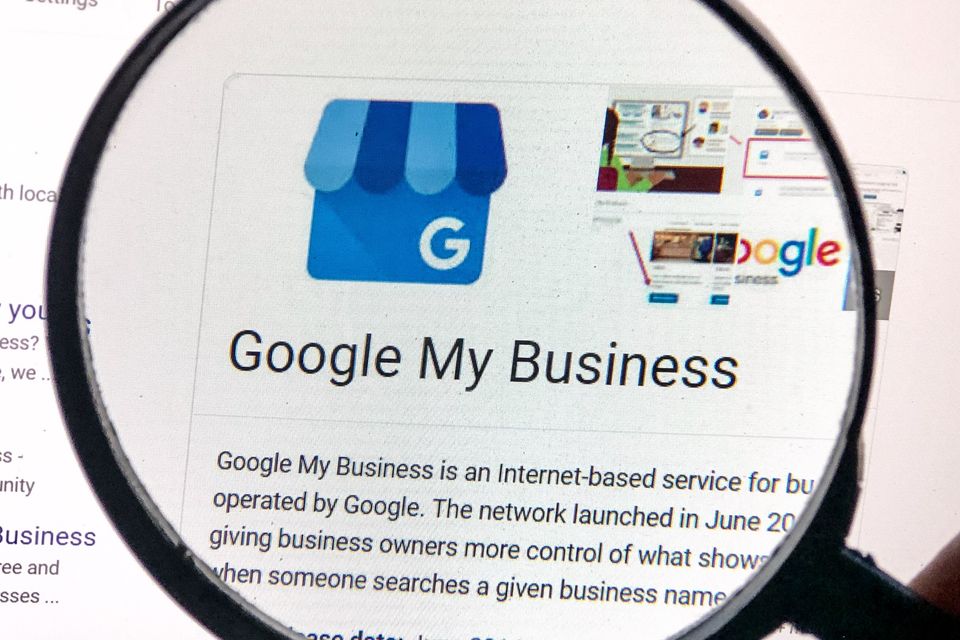 Magnifying glass hovering over a computer screen showing information about Google My Business.