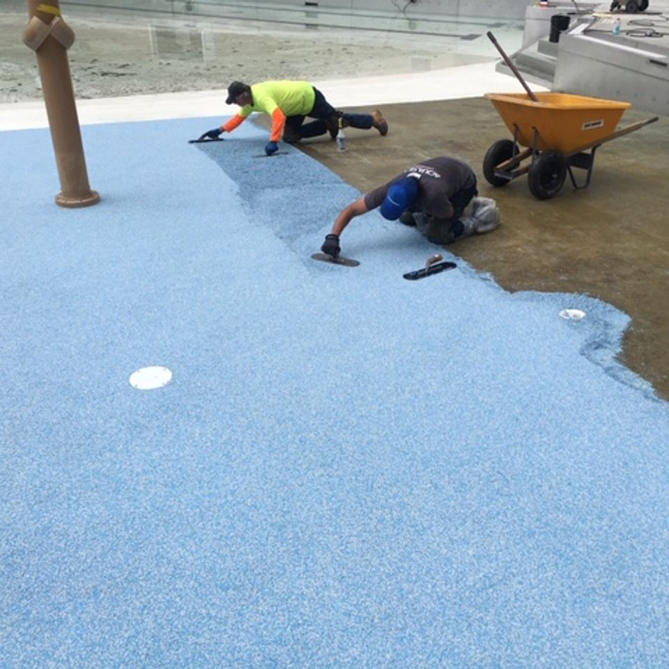 Contractors installing EverStone Flex around a pool deck.