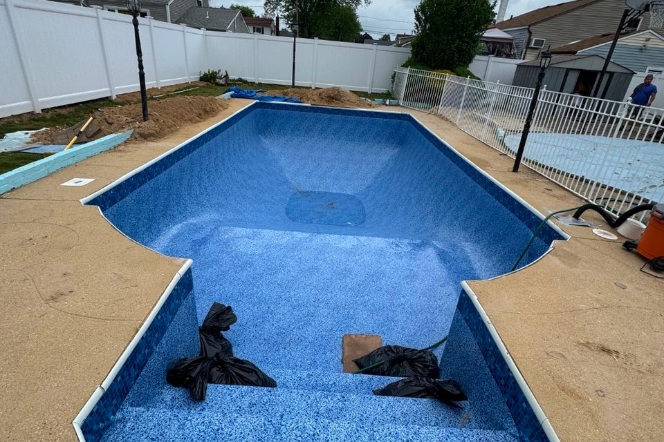 Blue mosaic pool liner installed in an empty inground pool before filling on Long Island NY