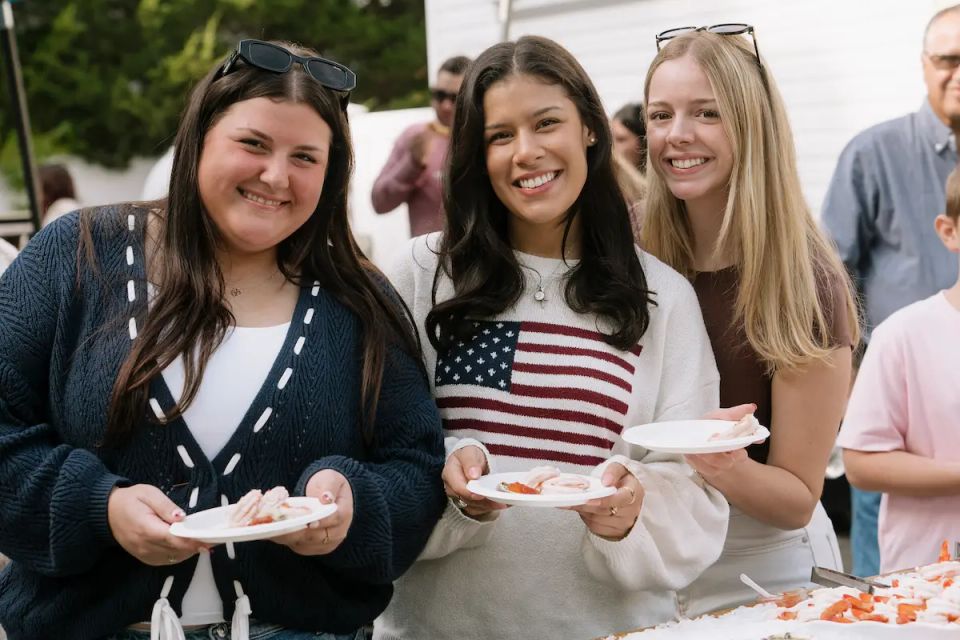 3 people having a fun time at a raw bar private event, catered by Shore2Shore Shucking of Long Island