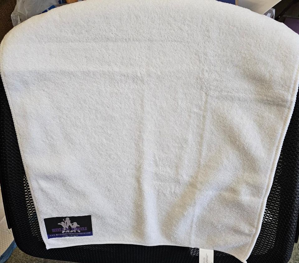 White towel featuring a Heels 'n Wheels logo patch in the corner.