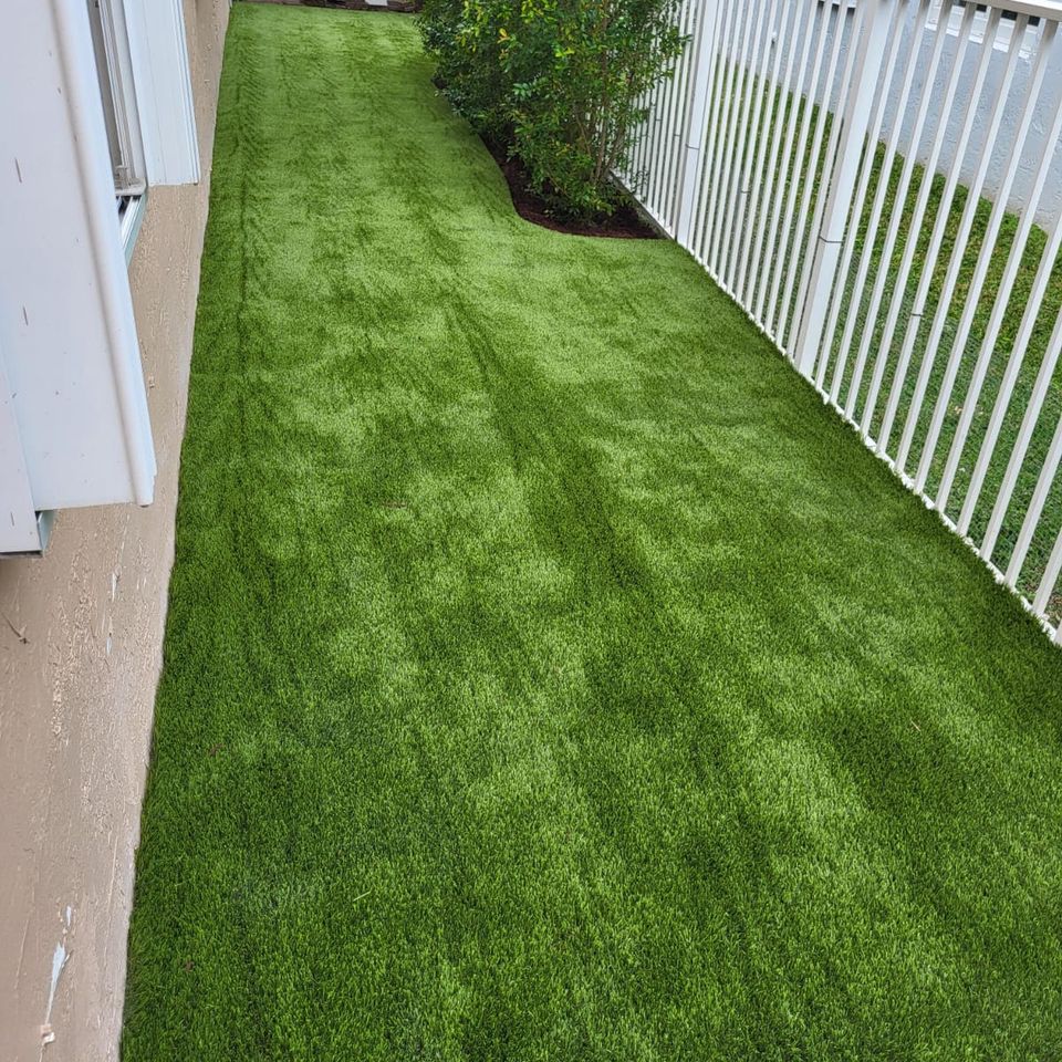 Fake grass completely installed near pink house