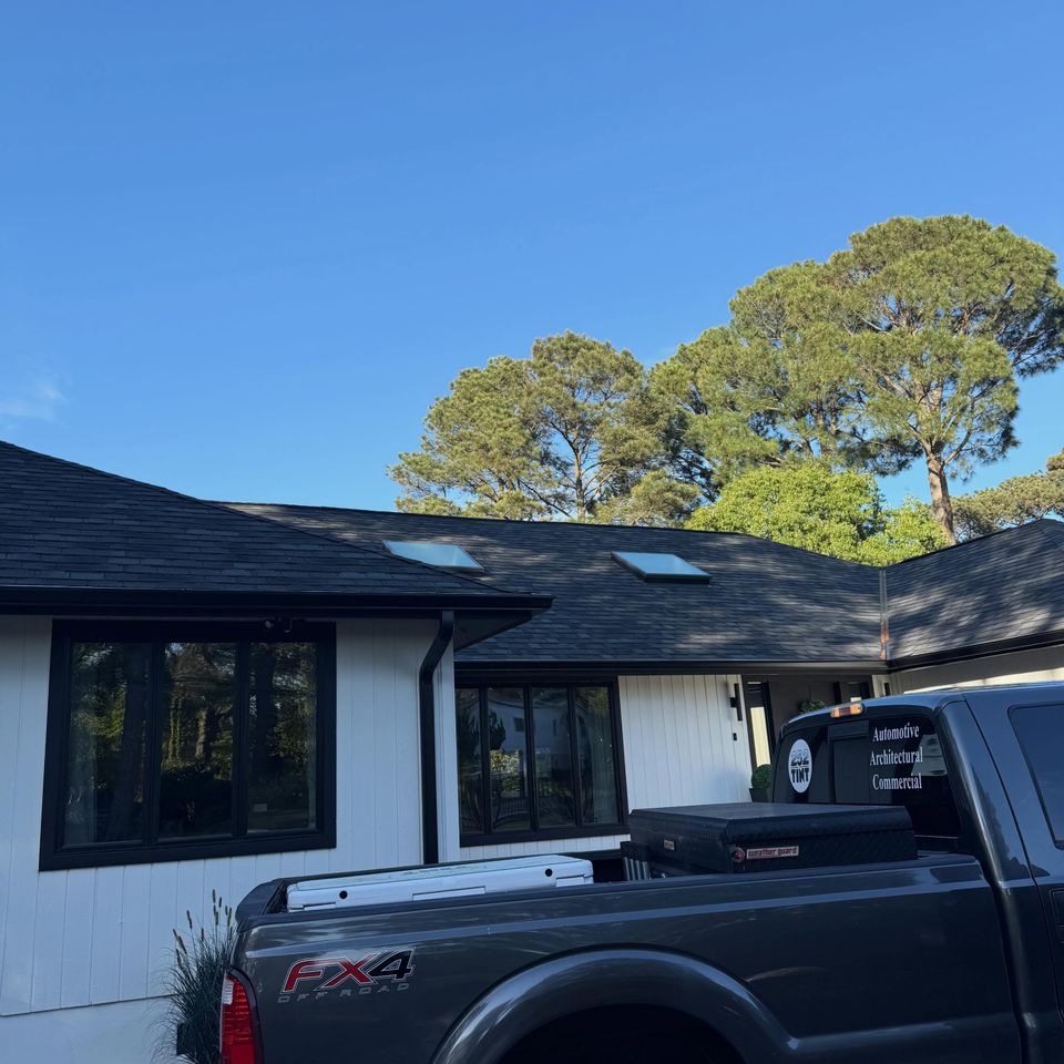 Black windows on a white ranch home with the 252 Tint truck parked in the driveway in Moyock NC