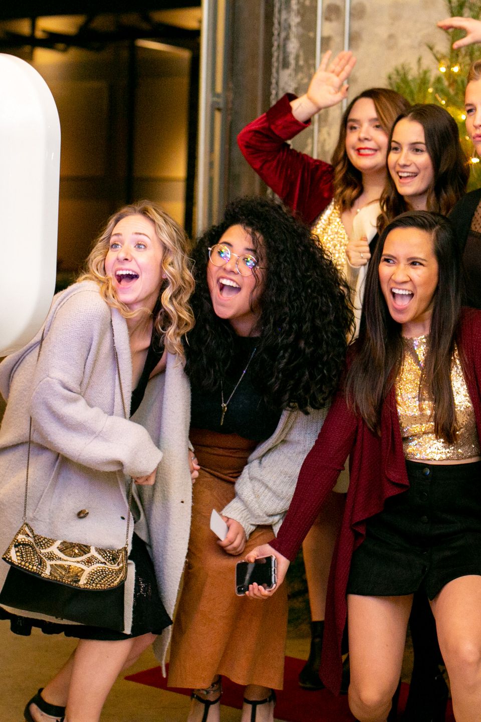 Guests laughing and posing in front of a digital photo booth at an event.