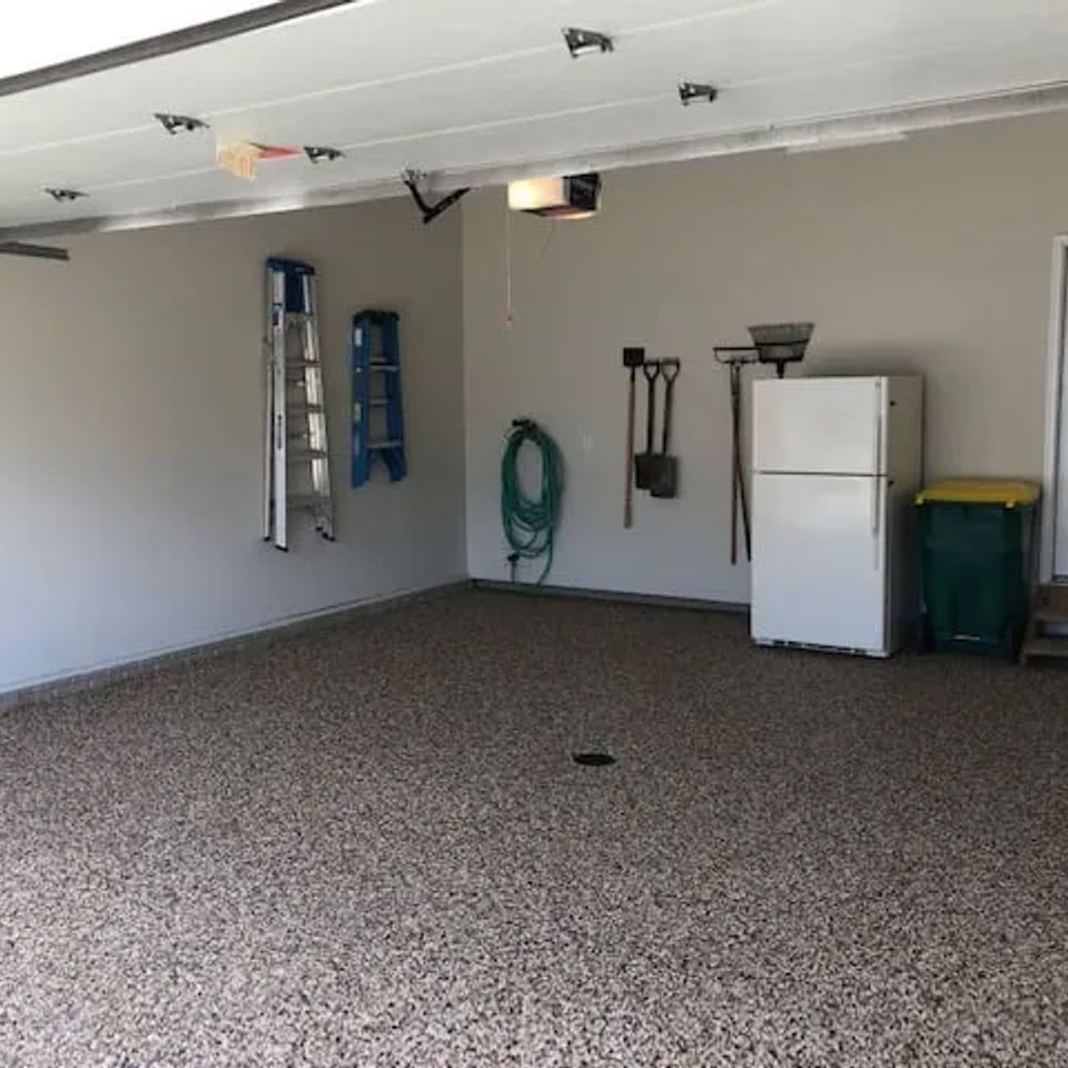 Residential garage featuring EverStone Epoxy Stone flooring with a natural stone finish.