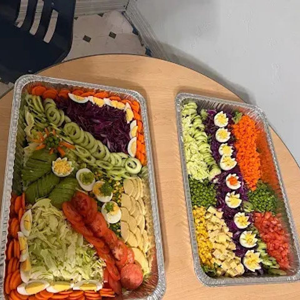 Two layered salad catering trays with boiled eggs, cucumber, avocado and tomatoes for an LA gathering