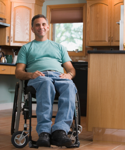 Smiling man in a wheelchair in his kitchen